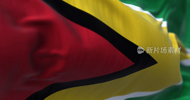 Close-up view of the Guyana national flag waving in the wind. The Co‑operative Republic of Guyana is a country on the northern mainland of South America. Fabric textured background. Selective focus